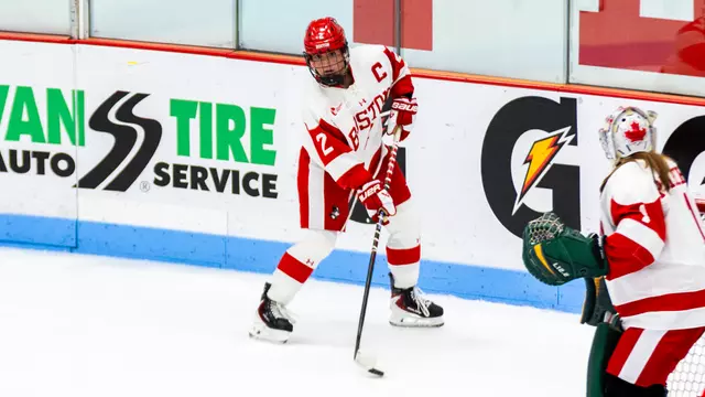Maeve Carey skates with the puck behind the net at home
