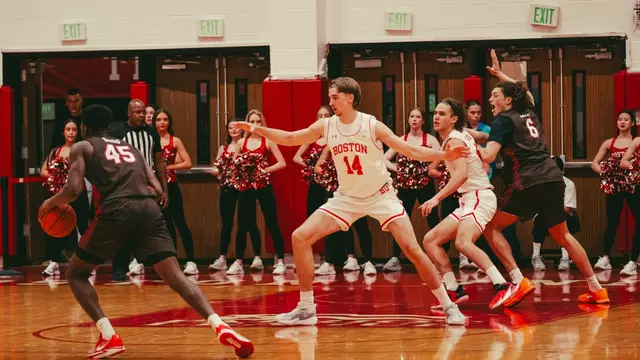 Men's basketball team on the court is in a defensive set with Brown passes the ball around the top of the arc.