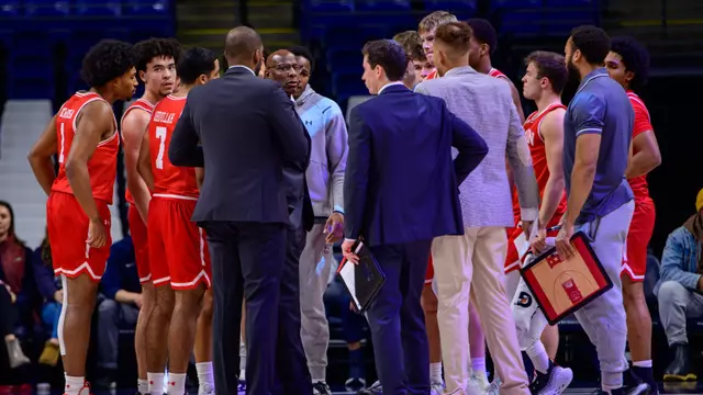 Men's Basketball team huddle with the players and coaches during a timeout