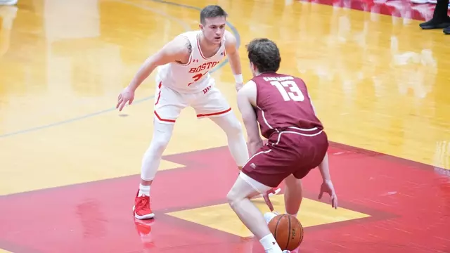 Ben Roy crouches to defend a Colgate player dribbling the ball up the court.