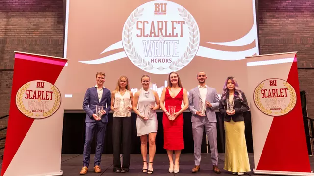 The major award winners gather at the podium for a group photo at the 2025 BU Athletic Scarlet & White Honors ceremony