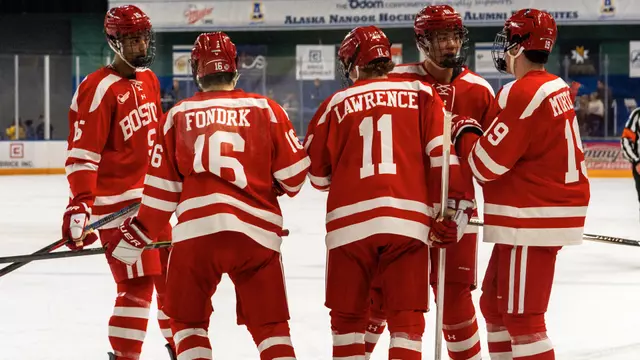 Men's ice hockey players huddle before a faceoff