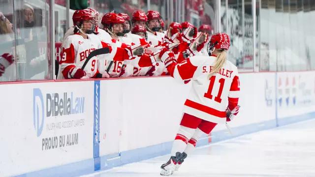 Sydney Healey high five players on bench after scoring at Walter Brown Arena
