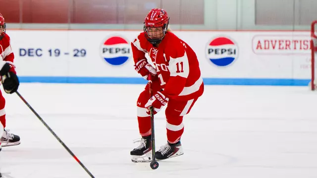 Sydney Healey skating with the puck in a red jersey