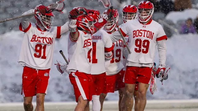 Men's lacrosse players celebrate a goal during their win against Siena