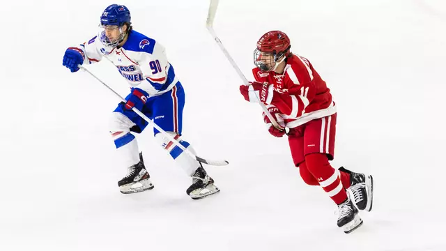 Tynan Lawrence skating next to a UMass Lowell player
