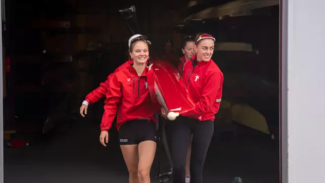 Photo of a BU Lightweight Rowing preparing to leave the DeWolfe Boathouse.