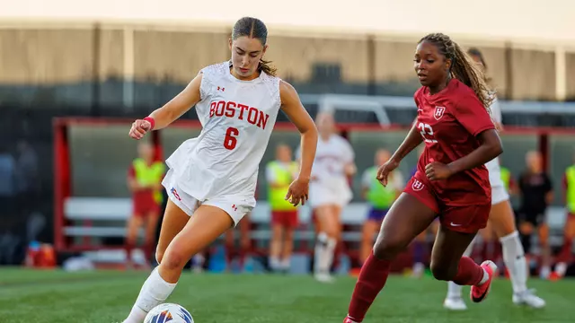 Photo of BU women's soccer senior Samantha Aronson dribbling the ball against a Harvard marker.