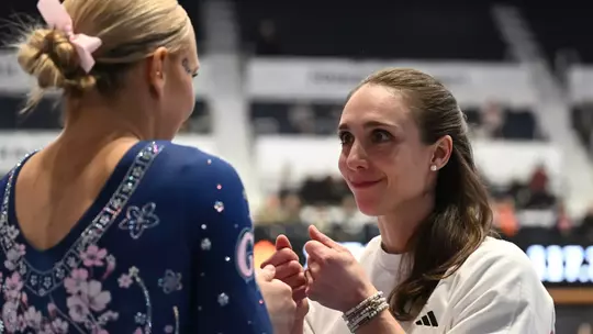 Stephanie Worrell gives Delaney DeHaan a pep talk before competing at Dare to Bloom meet.