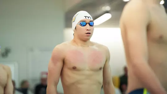 Daniel Choi standing on the pool deck ahead of a race