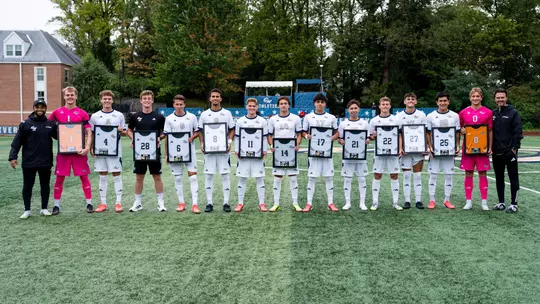 Men's Soccer seniors pose with senior posters