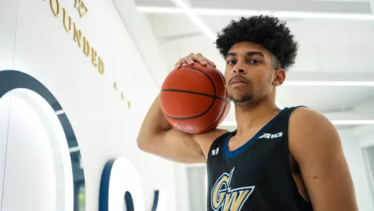 Felix Kossaras holds the basketball at a photoshoot