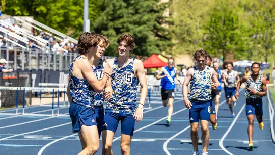 Men's Track huddles after racing