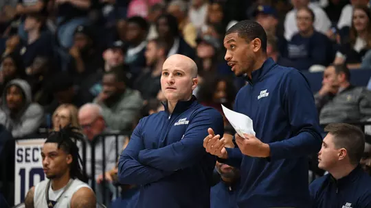 Aaron Thompson talks with Chris Caputo on the sideline during a game