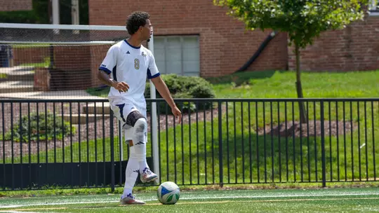 Jaden Dubon standing over the ball at the GW Soccer Field