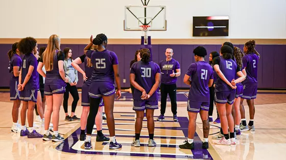 Women's basketball players huddle at practice inside the auxiliary gym at the Atlantic Union Bank Center.