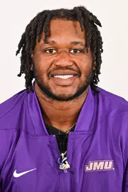 Mychal McMullin posed for headshot in purple quarter zip.