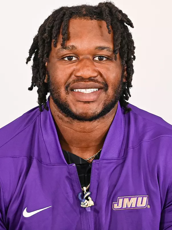 Mychal McMullin posed for headshot in purple quarter zip.