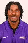KD Mosley posed for headshot in purple quarter zip.