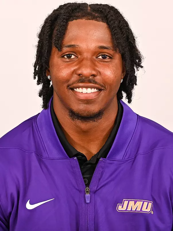 KD Mosley posed for headshot in purple quarter zip.