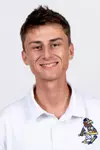 Studio headshot of a smiling young man with short brown hair, wearing a white collared Kent State baseball polo shirt against a plain white background.