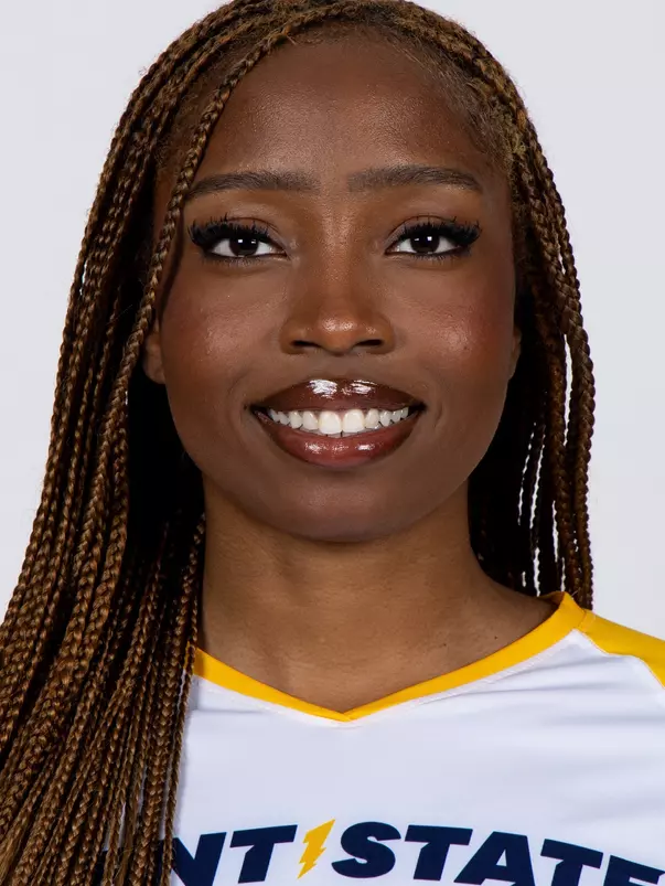 Studio headshot of a smiling young woman with long, braided brown hair, wearing a white Kent State athletic jersey against a plain white background.