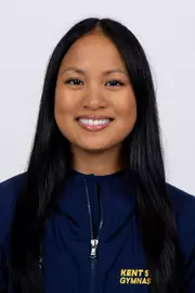 head shot of a Kent State gymnastics student-athlete smiling wearing a navy blue jacket on a white backdrop
