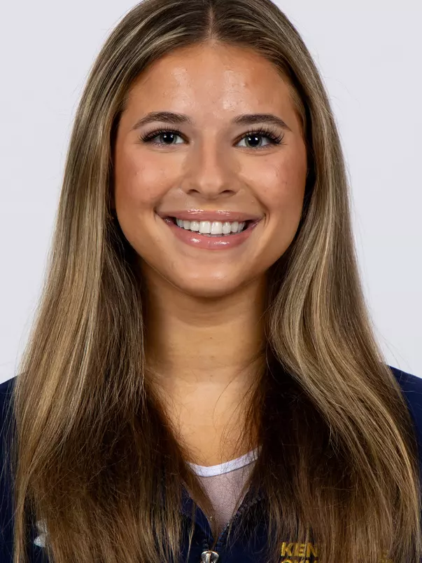 head shot of a Kent State gymnastics student-athlete smiling wearing a navy blue jacket on a white backdrop