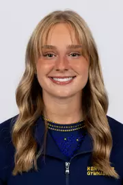 head shot of a Kent State gymnastics student-athlete smiling wearing a navy blue jacket on a white backdrop