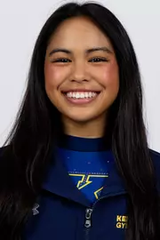 head shot of a Kent State gymnastics student-athlete smiling wearing a navy blue jacket on a white backdrop