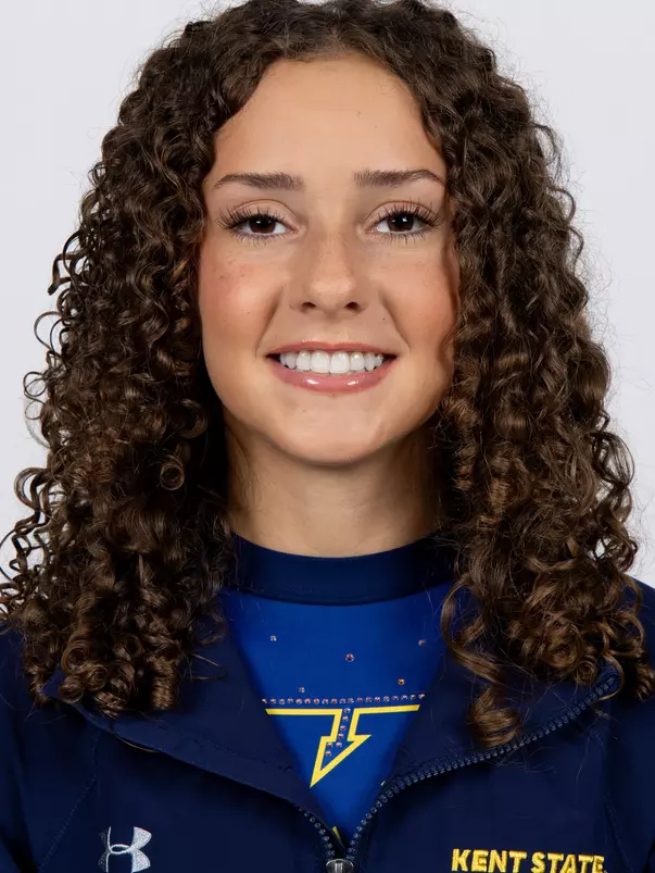 head shot of a Kent State gymnastics student-athlete smiling wearing a navy blue jacket on a white backdrop