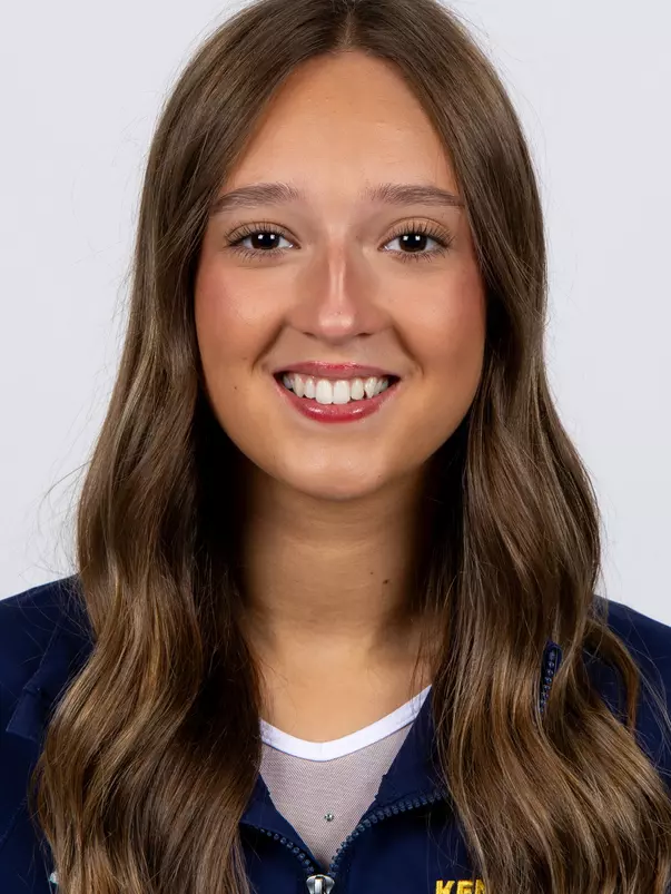 head shot of a Kent State gymnastics student-athlete smiling wearing a navy blue jacket on a white backdrop