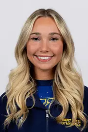 head shot of a Kent State gymnastics student-athlete smiling wearing a navy blue jacket on a white backdrop