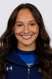 head shot of a Kent State gymnastics student-athlete smiling wearing a navy blue jacket on a white backdrop