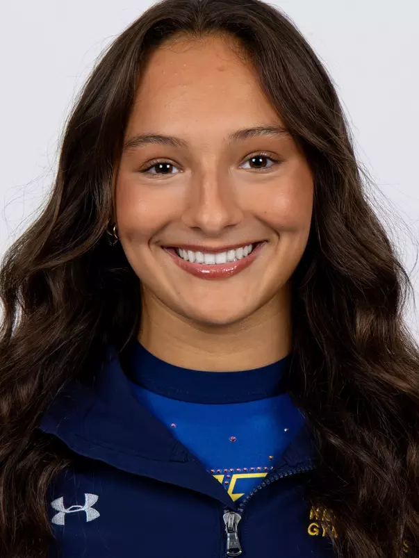 head shot of a Kent State gymnastics student-athlete smiling wearing a navy blue jacket on a white backdrop
