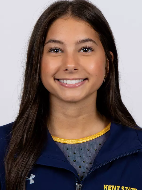 head shot of a Kent State gymnastics student-athlete smiling wearing a navy blue jacket on a white backdrop