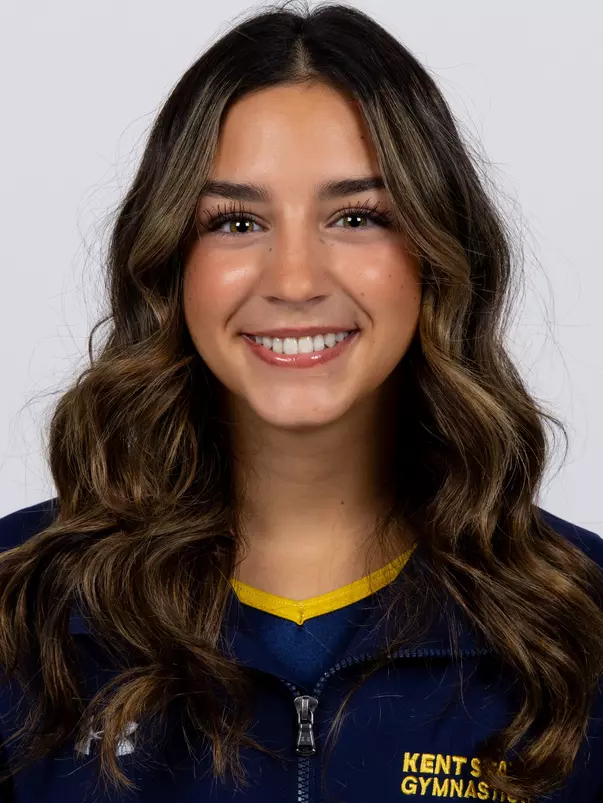 head shot of a Kent State gymnastics student-athlete smiling wearing a navy blue jacket on a white backdrop