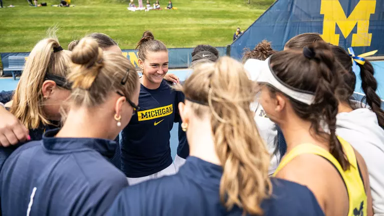 Women's tennis team huddle outdoors