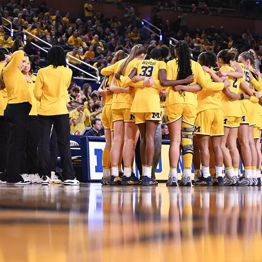 Women's basketball team huddle on court