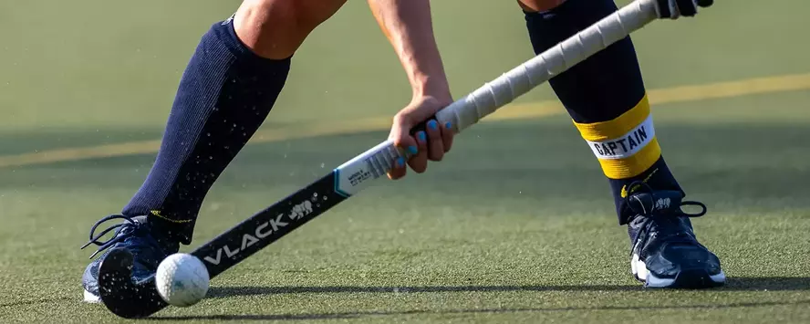 Field hockey player with a stick and ball