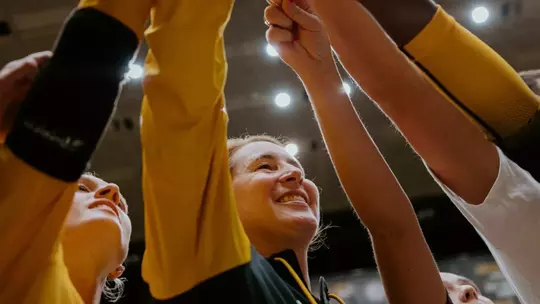 Dawn Sullivan in a group huddle with volleyball