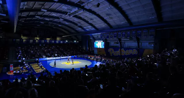 A wide shot of the interior of the Fitzgerald Field House with the lights down for a wrestling match.