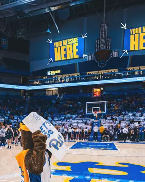 A photo of the videoboards above the IC Light Baseline club in the Petersen events center with "your message here" displayed on the boards.