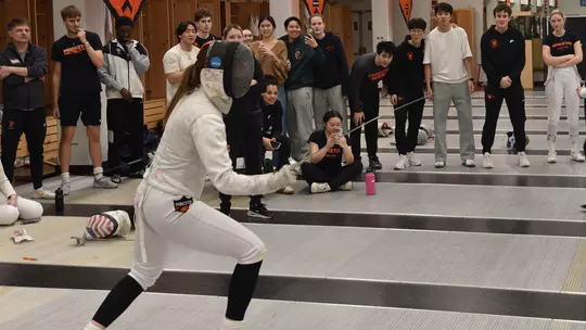 fencing action with fencer reaction behind