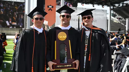 Men's lacrosse players with NCAA trophy at 2026 graduation