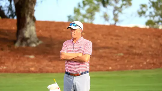 Adam Decker surveys the fairway with his arms crossed