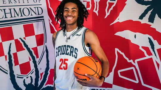 Jaden Shoultz poses with a ball in front of a Richmond Athletics backdrop