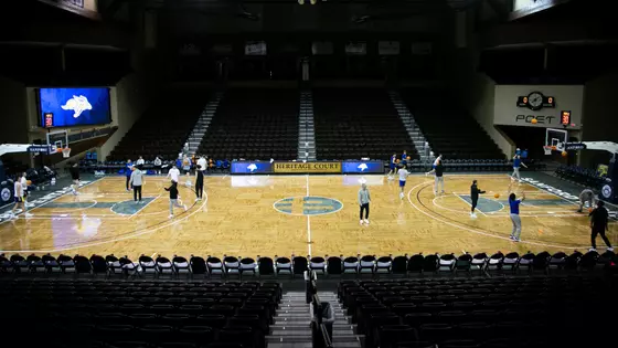 A picture with men's basketball players shooting basketball's on the Sanford Pentagon basketball court