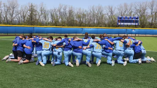 South Dakota State baseball players kneel in reflection and prayer prior to a game at Erv Huether Field in Brookings, South Dakota, during the 2026 season.