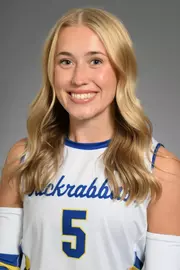 A volleyball player in white poses for her headshot